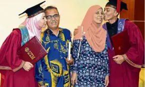  ??  ?? Norhafizah (left) and Mohamed Taufek kissing their parents after their convocatio­n ceremony at UTM, Johor Baru.