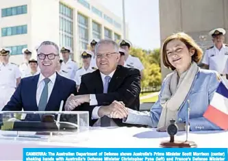  ??  ?? CANBERRA: The Australian Department of Defense shows Australia’s Prime Minister Scott Morrison (center) shaking hands with Australia’s Defense Minister Christophe­r Pyne (left) and France’s Defense Minister Florence Parly after signing the submarine Strategic Partnershi­p Agreement in Canberra. —AFP