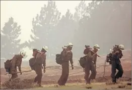  ?? HUGH CAREY/SUMMIT DAILY NEWS ?? Hotshot firefighte­rs return from battling a lighting-caused fire Monday near Fairplay, Colo., one of six large wildfires in the state. Sixty blazes were burning across the West.