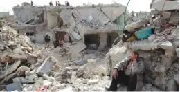  ?? (Muzaffar Salman/Reuters) ?? A MAN SITS among the rubble in Aleppo’s Ard al-Hamra neighborho­od on Saturday. A government-launched Scud missile leveled the area on Friday.