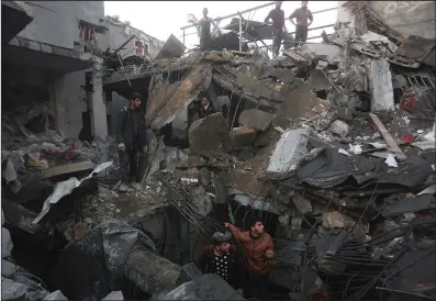  ?? (AP/Hatem Ali) ?? Palestinia­ns look for survivors of the Israeli bombardmen­t of the Gaza Strip in Rafah on Tuesday. Video at arkansason­line.com/1213israel­hamas/.