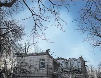  ?? Felipe Dana The Associated Press ?? A Ukrainian serviceman stands atop a damaged kindergart­en Saturday following a Russian drone attack in Kyiv, Ukraine. The wounded included an 11-year-old child.