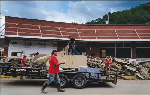  ?? (AP/Brynn Anderson) ?? Volunteers help clean up dirt and debris Friday off the main street in downtown Fleming-Neon, Ky. The previous week’s flooding damaged much of the town.