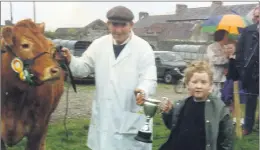  ?? (Pic: The Avondhu Archives) ?? Fergal Ó Murchú presenting Peter Reynolds, Johnstown, Glanworth with the Ryan Cup, for champion limousin at Fermoy show 1991.