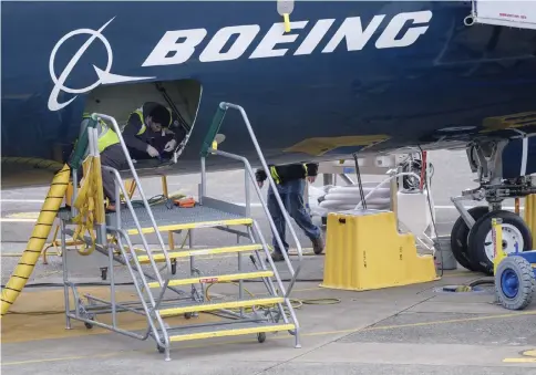  ?? — AFP photo ?? Employees work in the cargo hold of a Boeing 727 MAX 9 test plane outside the company’s factory, in Renton, Washington. The 737 MAX, Boeing’s newest model, has been grounded by aviation authoritie­s throughout the world after the crash of an Ethiopian Airlines 737 MAX 8 on March 10.