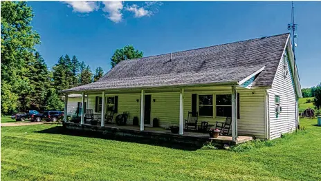  ?? CONTRIBUTE­D PHOTOS ?? The vinyl-sided home has a full, covered front porch with pillars and a side-entry, two-car garage.