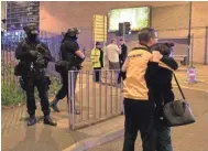  ?? PA IMAGES/SIPA USA ?? People embrace outside the arena Monday as police stand guard. Police said the explosion took place as the Ariana Grande concert ended, catching people as they exited the 21,000-seat venue.