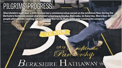  ?? Picture: Bloomberg ?? Shareholde­rs walk over a 50th Anniversar­y commemorat­ive carpet on the exhibition floor during the Berkshire Hathaway annual shareholde­rs meeting in Omaha, Nebraska, on Saturday. More than 40 000 people attended the meeting, which marked Warren...