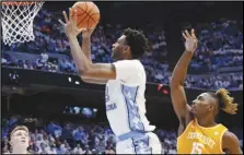  ?? Associated Press ?? North Carolina forward Jalen Washington (center) drives against Tennessee guards Dalton Knecht (left) and Jahmai Mashack (15) during the first half on Wednesday in Chapel Hill, N.C.