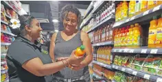  ?? Photo: Nicolette Chambers ?? Fresh Choice Supermarke­t head cashier, Shabana Nisha assisting customer, La Benedito on March 31, 2021.