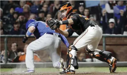  ??  ?? SAN FRANCISCO: San Francisco Giants catcher Buster Posey, right, tags out Chicago Cubs’ Kris Bryant at home plate as Bryant tried to score from third base on a ground ball from Willson Contreras during the seventh inning of a baseball game Monday, in...