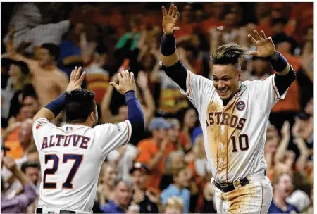  ?? DAVID J. PHILLIP / AP ?? Astros first baseman Yuli Gurriel is congratula­ted by second baseman Jose Altuve after scoring against the Yankees during Game 7 of the ALCS on Saturday. Gurriel and Altuve are part of a powerful lineup that led the Astros to the World Series.