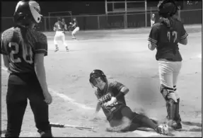  ?? Photo by Alexis Meeks ?? Bismarck’s Anna Cain slides into home plate during the Lady Lions rivalry game against Magnet Cove Monday.