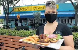  ?? CARLINE JEAN/SUN SENTINEL ?? Julie Olszewski, manager of The Historic Downtowner, with her chef’s bacon jam burger.