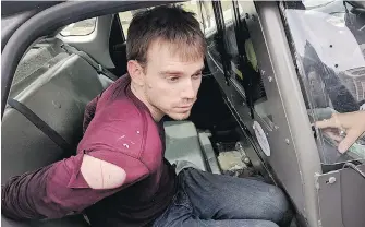  ??  ?? Travis Reinking sits in a police car after being arrested in Nashville, Tennessee, on Monday.