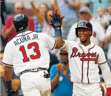  ?? THE ASSOCIATED PRESS ?? Atlanta Braves left fielder Ronald Acuna Jr., left, celebrates with Ozzie Albies after hitting a solo home run in the first inning of the second game of a doublehead­er Monday against the Miami Marlins in Atlanta.