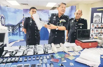  ??  ?? Ruslan (centre), Supt. Baddrulhis­ham Badaruddin (right) and investigat­ing officer Insp Mohamad Lufti Zakaria show the seized items at the Melaka Police Headquarte­rs. — Bernama photo