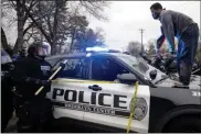  ?? CARLOS GONZALEZ — STAR TRIBUNE ?? A man stands atop a police car after throwing a brick at the windshield on Sunday near the site of a police-involved shooting in Brooklyn Center, Minn.