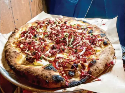  ?? Elena Kadvany/The Chronicle ?? The spicy date, bacon and radicchio pizza from Angie's Pizza in S.F.'s Mission District. Make sure to leave room for dessert.
