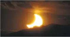  ?? ASSOCIATED PRESS FILE PHOTO ?? An annular solar eclipse is seen in 2012 as the sun sets behind the Rocky Mountains from downtown Denver. As many prepare to watch a total solar eclipse Monday, Native leaders advise tribal members to stay inside and treat event with ‘respect and...