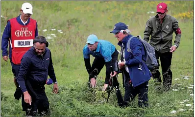  ?? AP/PETER MORRISON ?? Rory McIlroy (middle) receives help as he looks for his ball in the long rough on the first hole during Thursday’s first round of the British Open at Royal Portrush in Northern Ireland. McIlroy finished with a quadruple bogey on the hole and shot an 8-over 79 for the round.