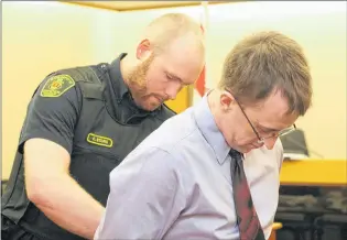  ?? TARA BRADBURY/THE TELEGRAM ?? A sheriff’s officer puts handcuffs on Thomas James Keeping, 32, before escorting him back to the lockup at provincial court in St. John’s Thursday morning, during a break in Keeping’s trial. He is facing a number of charges in connection with an...