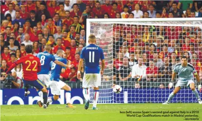  ?? – REUTERSPIX ?? Isco (left) scores Spain’s second goal against Italy in a 2018 World Cup Qualificat­ions match in Madrid yesterday.