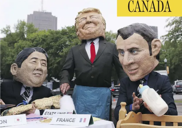  ?? LARS HAGBERG / AFP / GETTY IMAGES ?? Members of the global poverty eradicatio­n group OXFAM, dressed as Japanese Prime Minister Shinzo Abe, left, U.S. President Donald Trump and French President Emmanuel Macron, pose for pictures outside Quebec City’s legislatur­e ahead of the G7 summit on Thursday.