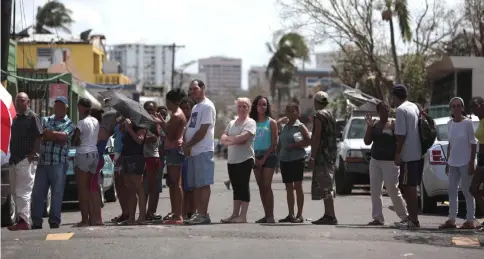  ??  ?? Waiting for the distributi­on of relief items in the aftermath of Hurricane Maria.