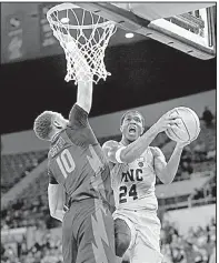  ?? AP/TIMOTHY J. GONZALEZ ?? North Carolina’s Kenny Williams drives to the basket against Arkansas’ Daniel Gafford (left) during the second half of the No. 9 Tar Heels’ 87-68 victory over the Razorbacks on Friday at the Phil Knight Invitation­al in Portland, Ore.