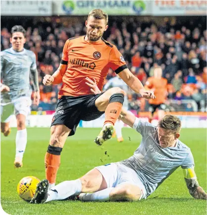  ??  ?? Dunfermlin­e’s Lee Ashcroft slides in to tackle United’s Pavol Safranko at Tannadice yesterday