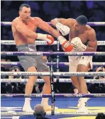  ?? PETER BYRNE/ASSOCIATED PRESS ?? British heavyweigh­t Anthony Joshua, right, lands a punch during Saturday’s title bout against Wladimir Klitschko in London.