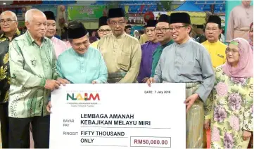  ??  ?? Abang Johari (second right) and Juma’ani (right) witness the handing-over of the mock cheque from Bateman (left) to Abdillah (second left).