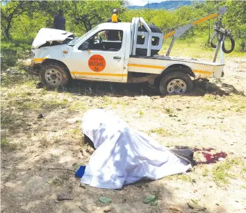  ??  ?? The body of one of the council workers lie next to the extensivel­y damaged city traffic enforcemen­t vehicle at 22 Miles in Marange.