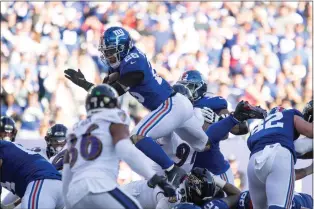  ?? RICH HUNDLEY III — FOR THE TRENTONIAN ?? Giants running back Saquon Barkley (26) leaps into the end zone for a touchdown against the Ravens during a NFL game on Sunday at MetLfie Stadium in East Rutherford.