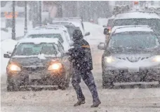  ?? STEVEN SENNE, AP ?? A pedestrian crosses the street during a snowstorm Sunday in Waltham, Mass. Boston public schools were closed Monday.