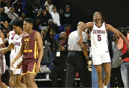  ?? (Pine Bluff Commercial/I.C. Murrell) ?? Pine Bluff High School junior Courtney Crutchfiel­d jumps for joy at the final horn of the 5A state championsh­ip game against Lake Hamilton on Thursday in Hot Springs.