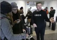  ?? THE ASSOCIATED PRESS FILE PHOTO ?? An Uber representa­tive helps travelers find rides with Uber at LaGuardia Airport in New York.