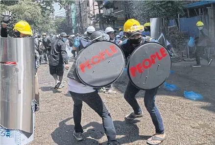 ?? AFP ?? Protesters hold shields with the word ‘PEOPLE’ on them during a demonstrat­ion against the military coup in Yangon, Myanmar on Sunday.