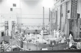  ?? IDAHO NATIONAL LABORATORY 2013 ?? Nuclear operations profession­al personnel work above the Advanced Test Reactor at Idaho National Laboratory’s desert site near Idaho Falls.