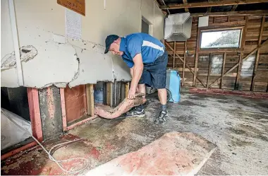  ?? BRADEN FASTIER/ STUFF ?? Steve Clifton of Jae’s removes sodden insulation from the walls of a flood-damaged home in Ruby Bay, Tasman district.