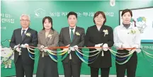  ?? Courtesy of Hana Financial Group ?? Hana Financial Group Chairman Ham Young-joo, center, cuts the tape to celebrate the launch of an around-the-clock child care center at Junggye-dong in Nowon District, northeaste­rn Seoul, Tuesday.