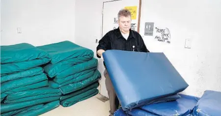  ?? SUSAN STOCKER/SUN SENTINEL ?? James Whitworth, of the Broward Outreach Center in Hollywood, keeps bed mats in storage due to suspension of the facility's overnight shelter program serving the homeless. The Miami Rescue Mission that runs the center is in negotiatio­ns with the county on a new contract.