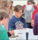  ?? Contribute­d ?? William Parish of the Junior Team judges cellphone plans during the 4-H area contest.