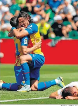  ?? MANUELO LORENZO / EFE ?? Gayá y Cavani se abrazan tras el segundo gol