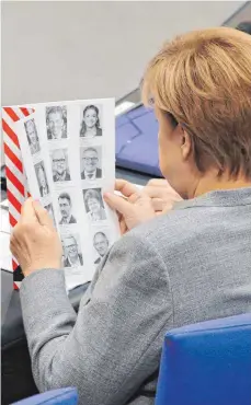  ?? FOTO: DPA ?? Neue Gesichter: Bundeskanz­lerin Angela Merkel (CDU) informiert sich während der konstituie­renden Sitzung des 19. Bundestage­s.