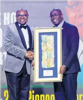  ?? PHOTO BY ASHLEY ANGUIN ?? Minister of Tourism Edmund Bartlett (left) accepts the Pioneer Award from Group CEO at the RJRGLEANER Communicat­ions Group, Gary Allen.