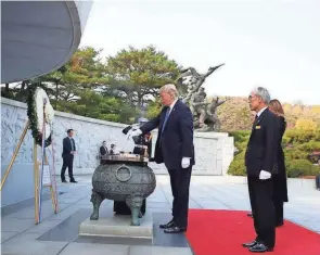  ?? POOL PHOTO BY JEON HEON KYUN ?? President Trump burns incense during his visit Wednesday to the National Cemetery in Seoul.