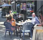  ?? Steve Barnes / Times Union ?? Diners eat outside at Dawn’s Victory Sports Cafe in Albany on June 4. A new state mandate requires that only patrons who are ordering and eating food can be served alcoholic beverages at bars and restaurant­s. The goal is to limit crowding.