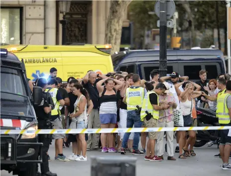  ?? Josep Lago / AFP ?? Police check the identity of people after a van ploughed into the crowd killing two in Barcelona, Spain, on August 17